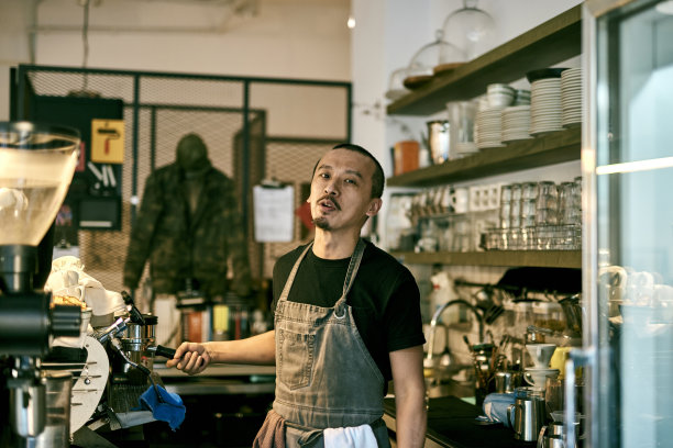 亚洲咖啡馆老板在咖啡店的照片。年轻的亚洲咖啡师正在制作冰咖啡。图片下载