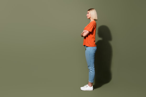 全长照片金发模特女孩交叉双手自信地看空空间经销商中心和孤立的卡其色背景图片下载