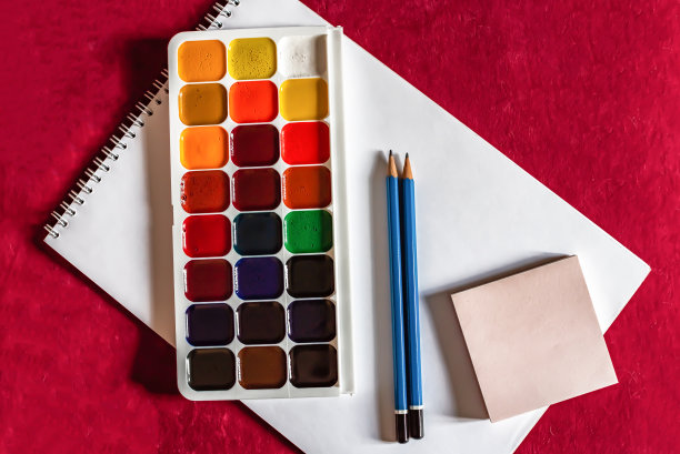 彩色的水彩或丙烯酸颜料和铅笔在白色的纸上，白色的背景。设计工作室桌面视图。图片下载