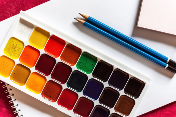 彩色的水彩或丙烯酸颜料和铅笔在白色的纸上，白色的背景。设计工作室桌面视图。图片下载