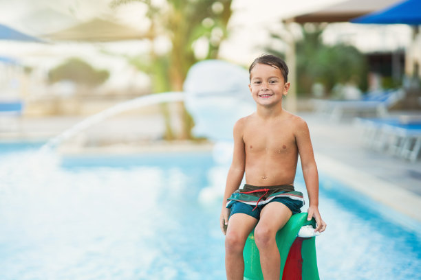 小男孩在户外水上公园玩耍的照片图片下载