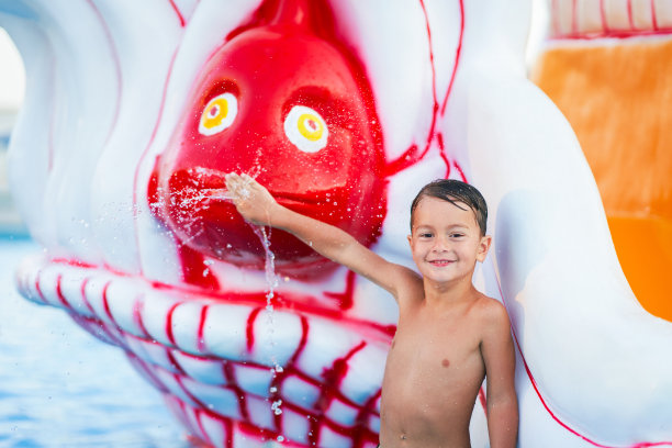 小男孩在户外水上公园玩耍的照片图片下载