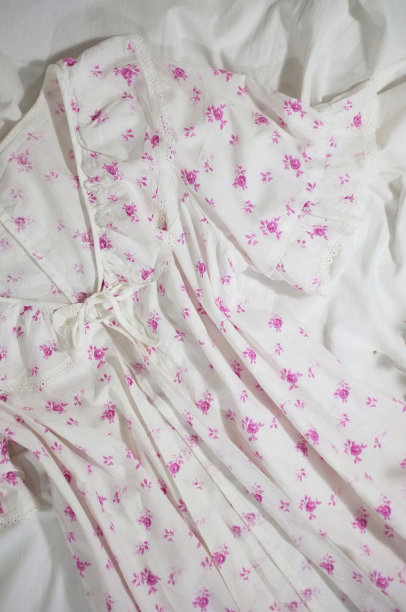 女性复古睡衣的家庭和睡眠与花卉印花。复古的平面照片在一个白色的背景与野花。褶皱布料上的女孩睡衣。小屋的审美。图片下载