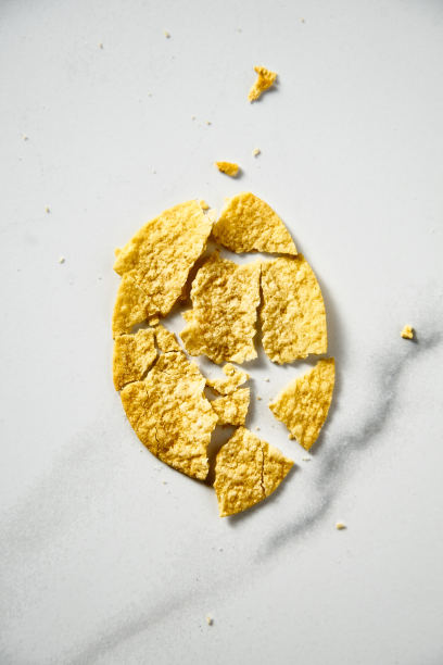 白色大理石背景上碎薯片的特写。极简的食物照片。俯视图图片下载