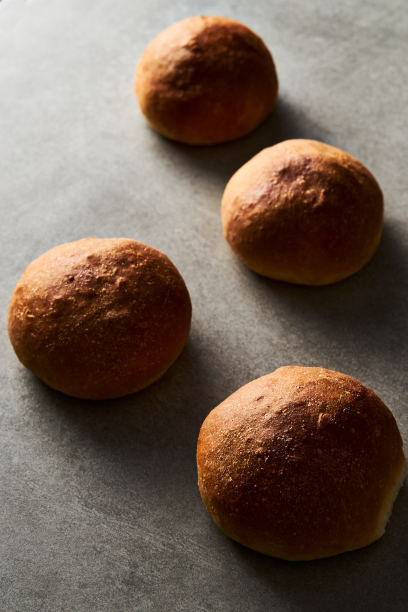 灰色混凝土背景上的汉堡面包或迷你面包。非常柔软的新鲜出炉的自制，涂了黄油。简约的照片。图片下载