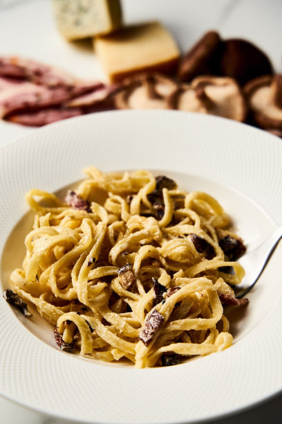 阿尔弗雷多意大利面与香菇和洋蓟在白色大理石背景。极简的食物照片。图片下载