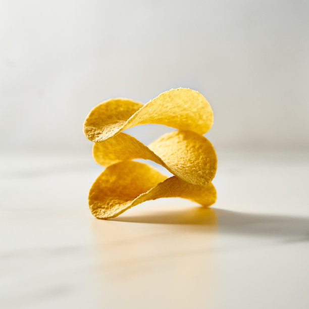 白色大理石背景上脆脆的薯片堆或塔。极简的食物照片。图片下载