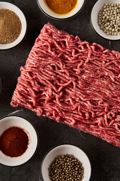 生的和新鲜的碎牛肉与香料烹饪在黑色大理石背景。极简的美食照片，低调。俯视图，复制空间图片下载