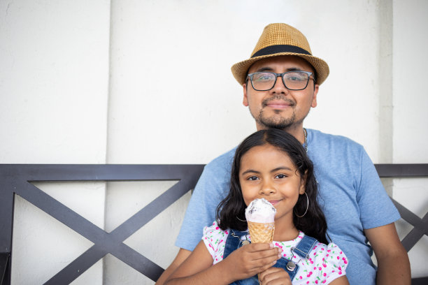 爸爸和孩子在公园户外吃冰淇淋的照片图片下载