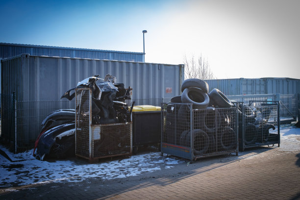 在一家汽车修理店的院子里，装满旧轮胎和汽车零件的集装箱图片下载