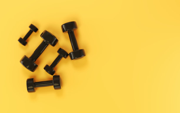 黑色塑料哑铃坐在柔软的黄色背景图片下载