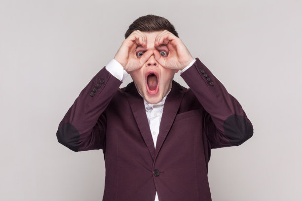 男人用双筒望远镜看，表示惊讶，放大视野。图片下载