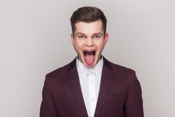 一名男子站在那里，张大嘴巴看着镜头，露出舌头。图片下载