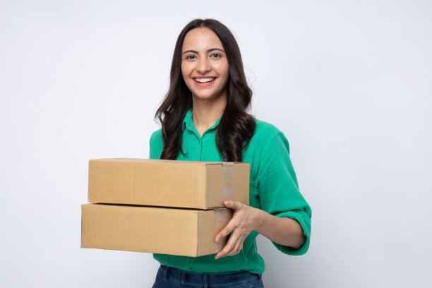 一个快乐的女人刚刚收到了几个包裹，这些包裹是她在一家摄影棚的库存照片中网购的东西图片下载
