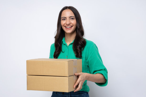 一个快乐的女人刚刚收到了几个包裹，这些包裹是她在一家摄影棚的库存照片中网购的东西图片下载