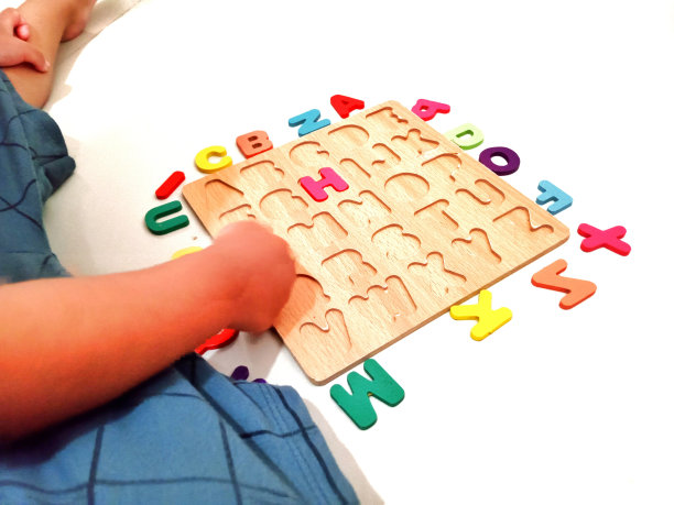 一个孩子正在玩字母表中的字母图片下载