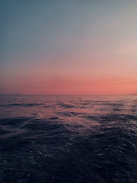 粉红色的夕阳在海中央。库存图片图片下载