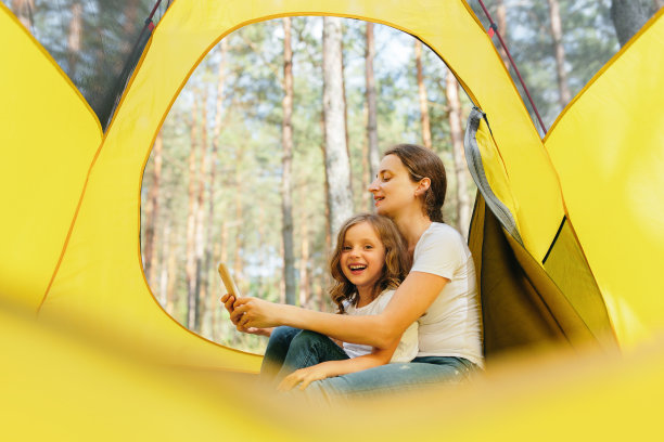 一位母亲和她的孩子在旅游帐篷里拍摄大自然的照片。图片下载