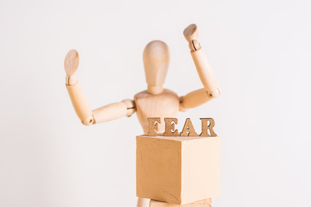 “恐惧”这个词出现在一个木头人的背景上，他的手举在一盏灯上图片下载