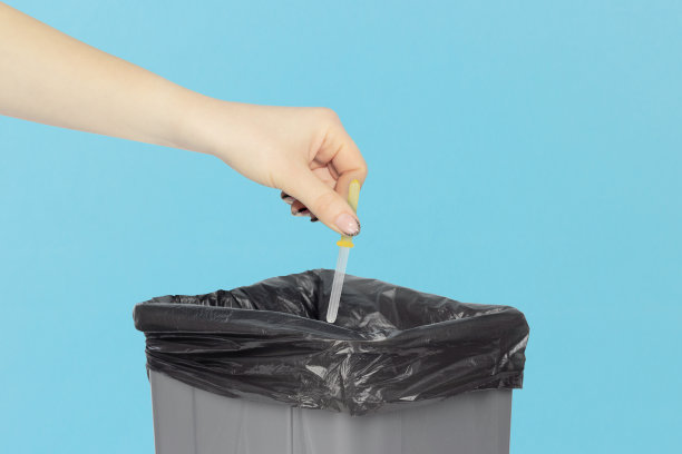 把移液器扔进垃圾桶，把鼻移液器放在手上的垃圾桶前，医疗器械回收利用的理念。忘记过敏图片下载