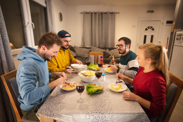 一群快乐的年轻人在一起享用晚餐，朋友们在一起吃饭图片下载