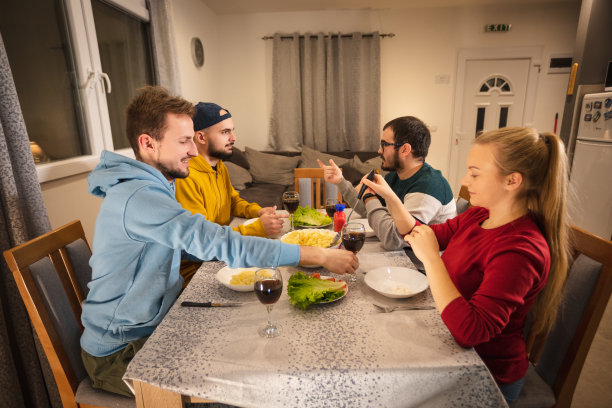 一群快乐的年轻人在一起享用晚餐，朋友们在一起吃饭图片下载