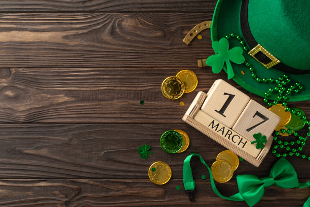 圣帕迪的魅力展示:俯视图照片，以木制立方体日历，小妖精的帽子，领结，幸运马蹄铁，硬币，三叶草，彩纸，珠子项链在木制背景与文本区域图片下载