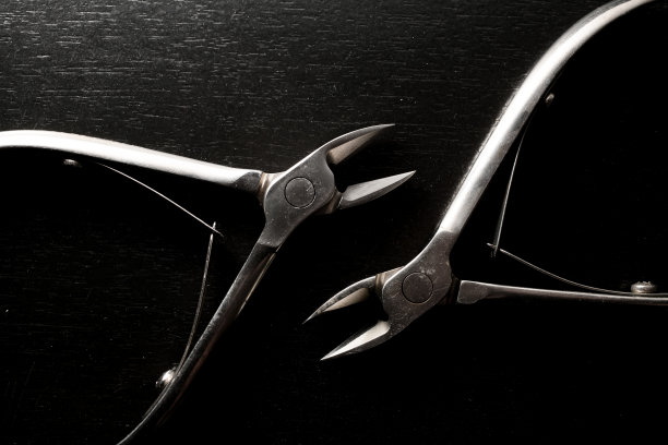 金属钢光泽角质层美甲钳工具黑色背景图片下载