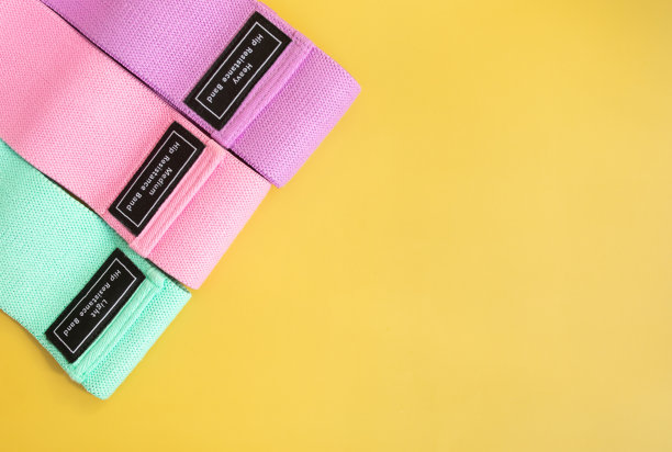 一套明亮的多色橡皮筋健身黄背景。图片下载