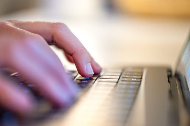 一个女人在笔记本电脑上打字的特写镜头图片下载