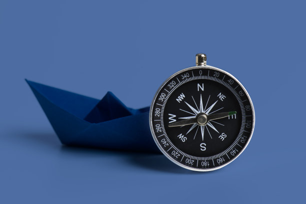 带指南针的橙色纸船图片下载