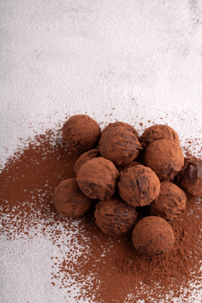 照片自制的巧克力松露，上面撒上可可粉，给人一种美食的感觉。这些圆形的美食是甜蜜的庆祝活动的完美选择。图片下载