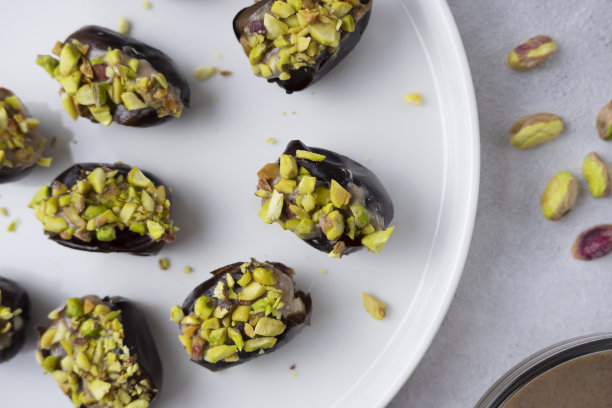 花生酱馅的开心果枣，自制的素食小吃，白色背景的填充甜点。健康的素食理念。图片下载