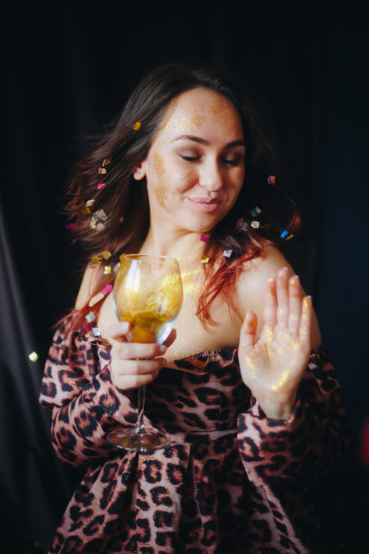 女子拿着玻璃与金色闪光吹彩纸股票照片图片下载