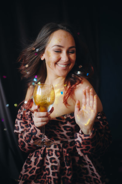 女子拿着玻璃与金色闪光吹彩纸股票照片图片下载