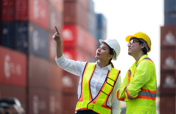 亚洲女工程师和工人与同事在海外航运集装箱堆场工作的肖像。图片下载