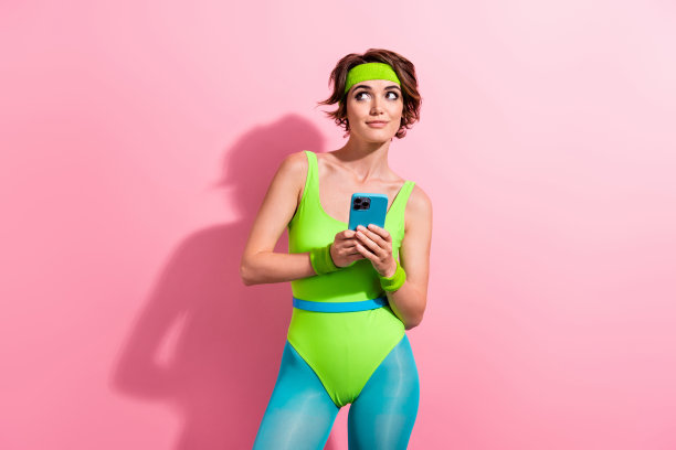 照片中可爱体贴的女人穿着霓虹灯运动紧身衣聊天现代设备空白空间孤立粉红色背景图片下载