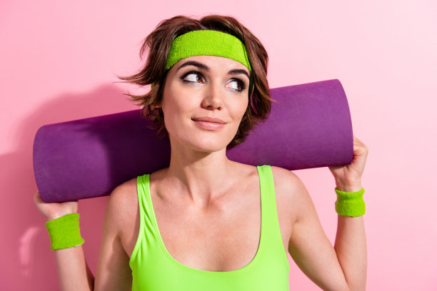 照片的专业教练女士动机做运动与健身垫孤立柔和的颜色背景图片下载