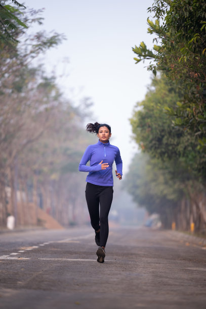 快乐的女跑步者在大自然中晨跑。库存图片图片下载
