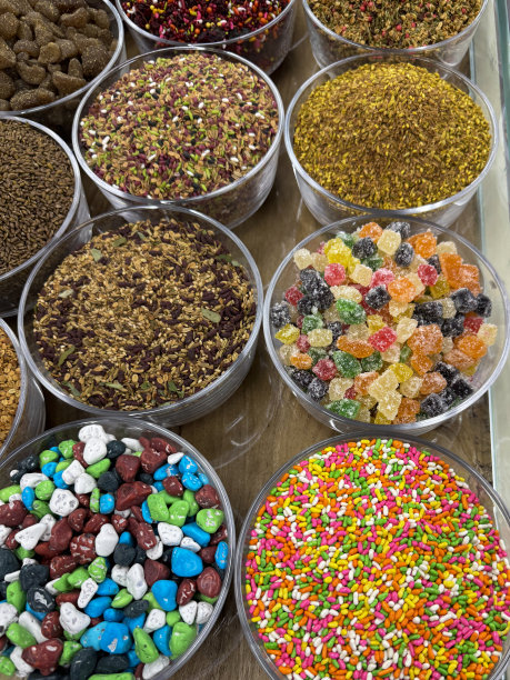 全画幅图片，一排排玻璃碗里装着五颜六色的口腔清新剂(Mukhwas)，水果味的，糖果摊上卖糖果的软糖，街头食品市场，茴香籽被涂上了五颜六色的糖，高架视图图片下载