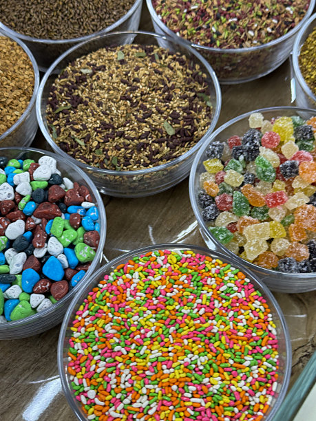 全画幅图片，一排排玻璃碗里装着五颜六色的口腔清新剂(Mukhwas)，水果味的，糖果摊上卖糖果的软糖，街头食品市场，茴香籽被涂上了五颜六色的糖，高架视图图片下载