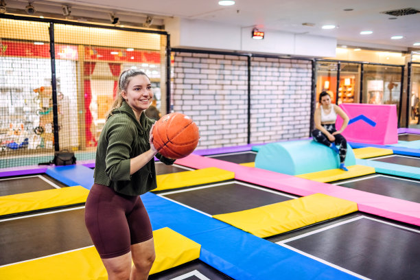 在孩子们的操场上，年轻的女孩正准备用篮球投篮图片下载