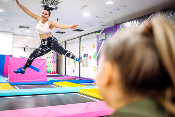 戴着耳机在蹦床上跳的女人图片下载