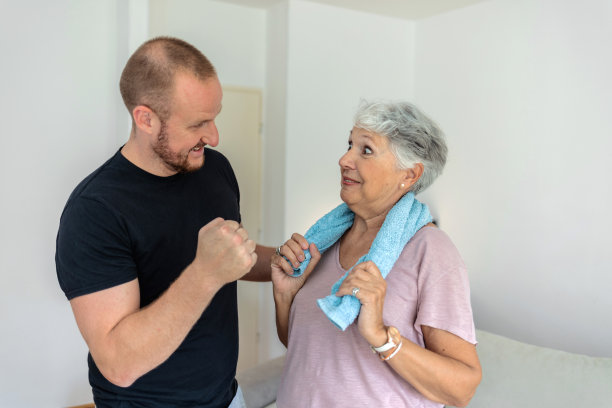 一名高级女性在家里准备和一名男教练一起锻炼的剪辑照片。图片下载