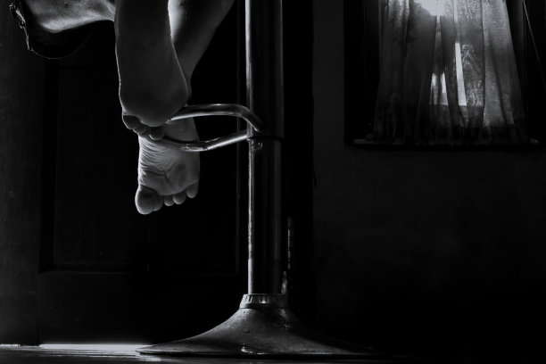 坐在椅子上的人的腿，坐在昏暗房间里的人的腿图片下载