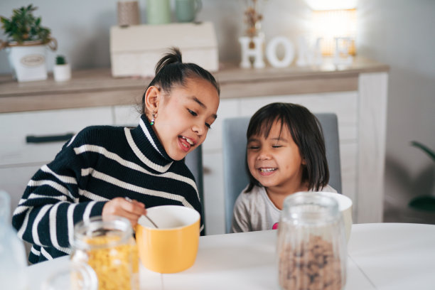 两姐妹在一起吃早餐麦片加牛奶的照片图片下载