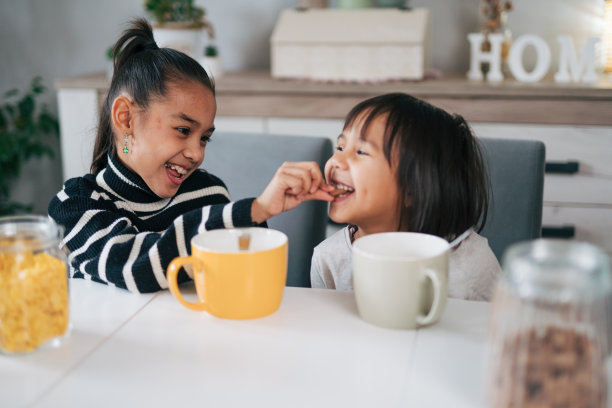 两姐妹在一起吃早餐麦片加牛奶的照片图片下载