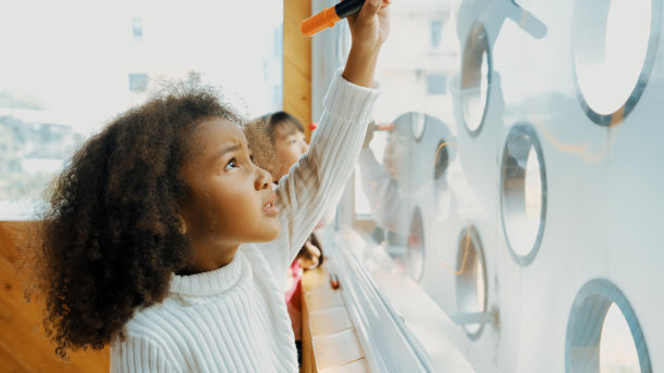 美术课上创意学生在玻璃板上画画的特写。博学。图片下载