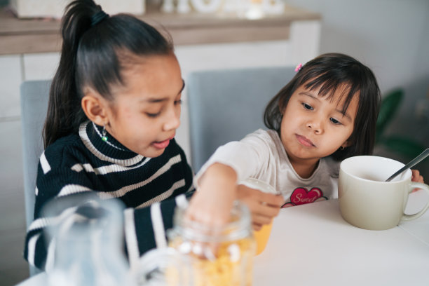 两姐妹在一起吃早餐麦片加牛奶的照片图片下载