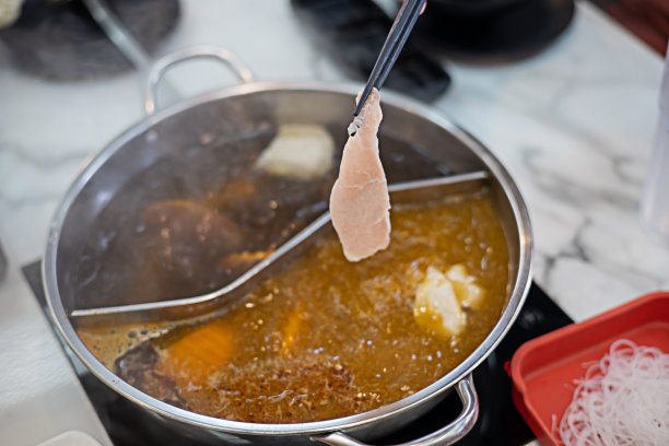 涮菜馆用筷子煮猪肉。关注筷子图片下载
